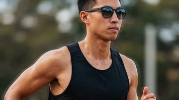 Male runner wearing 2nu sunglasses during an outdoor track run, showing sweat and stable frame fit for Hong Kong running conditions